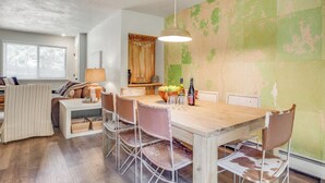 Ein Essbereich mit Holztisch, Stühlen und einer Hängelampe.