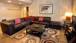 A living room with a sectional sofa, a coffee table, and a patterned rug. - Sleeps 8 w Loft | 3 Baths, Hot Tub & Tennis (Mammoth Lakes)