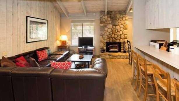 A living room with a sectional sofa, a fireplace, and a bar area. - Sleeps 8 w Loft | 3 Baths, Hot Tub & Tennis (Mammoth Lakes)