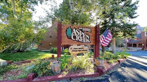 Un panneau en bois indique l’entrée d’Aspen Creek et précise qu’il s’agit d’une propriété privée et qu’un permis de stationnement est obligatoire.
