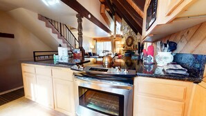 A kitchen with a built-in oven, a stainless steel range, and a stone backsplash.