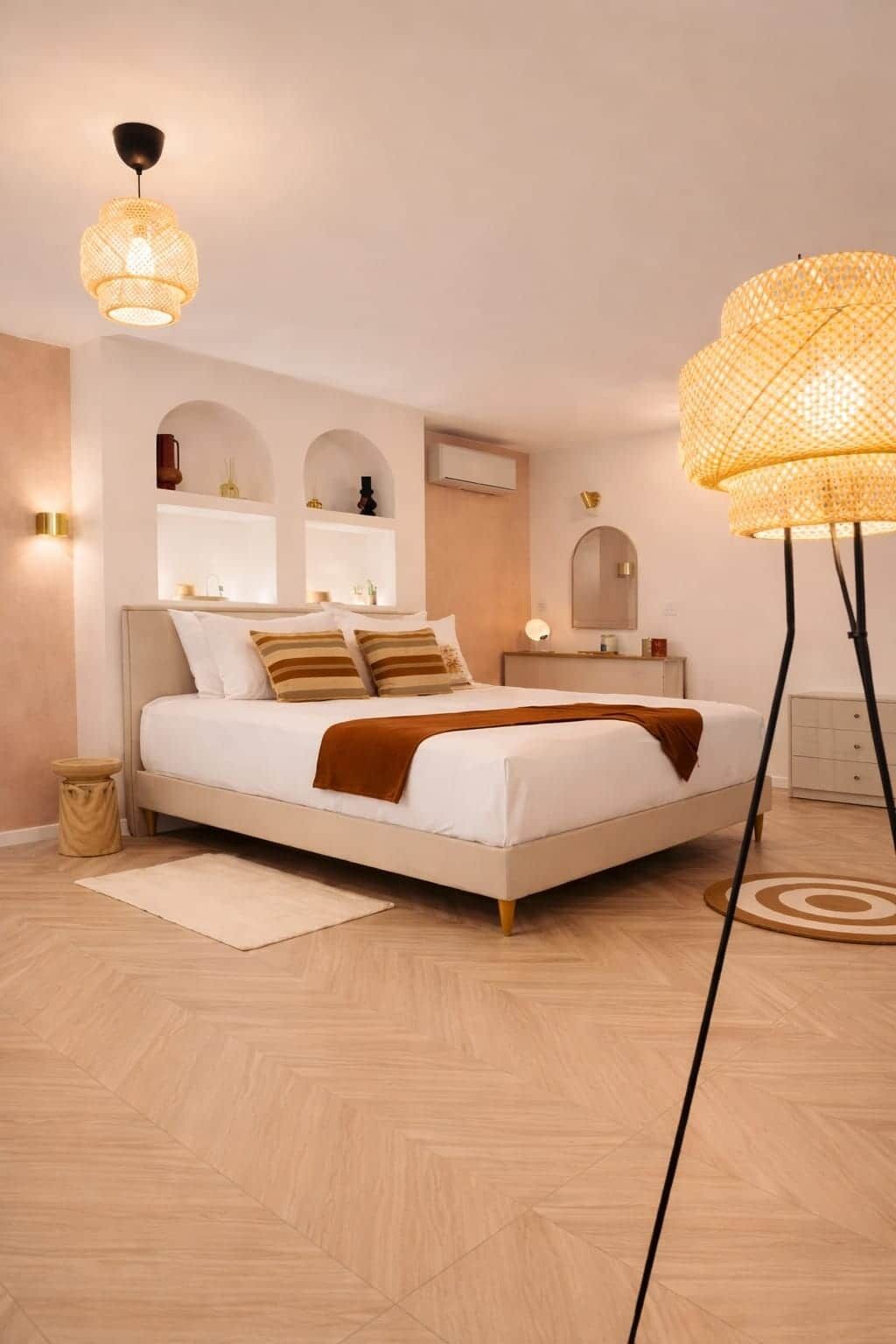 Une chambre à coucher moderne avec un lit, des tables de chevet et une lampe sur pied.