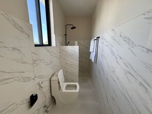 A modern bathroom with a toilet, shower, and marble walls. - Rafiki Hotel Nungwi Beach (Nungwi)