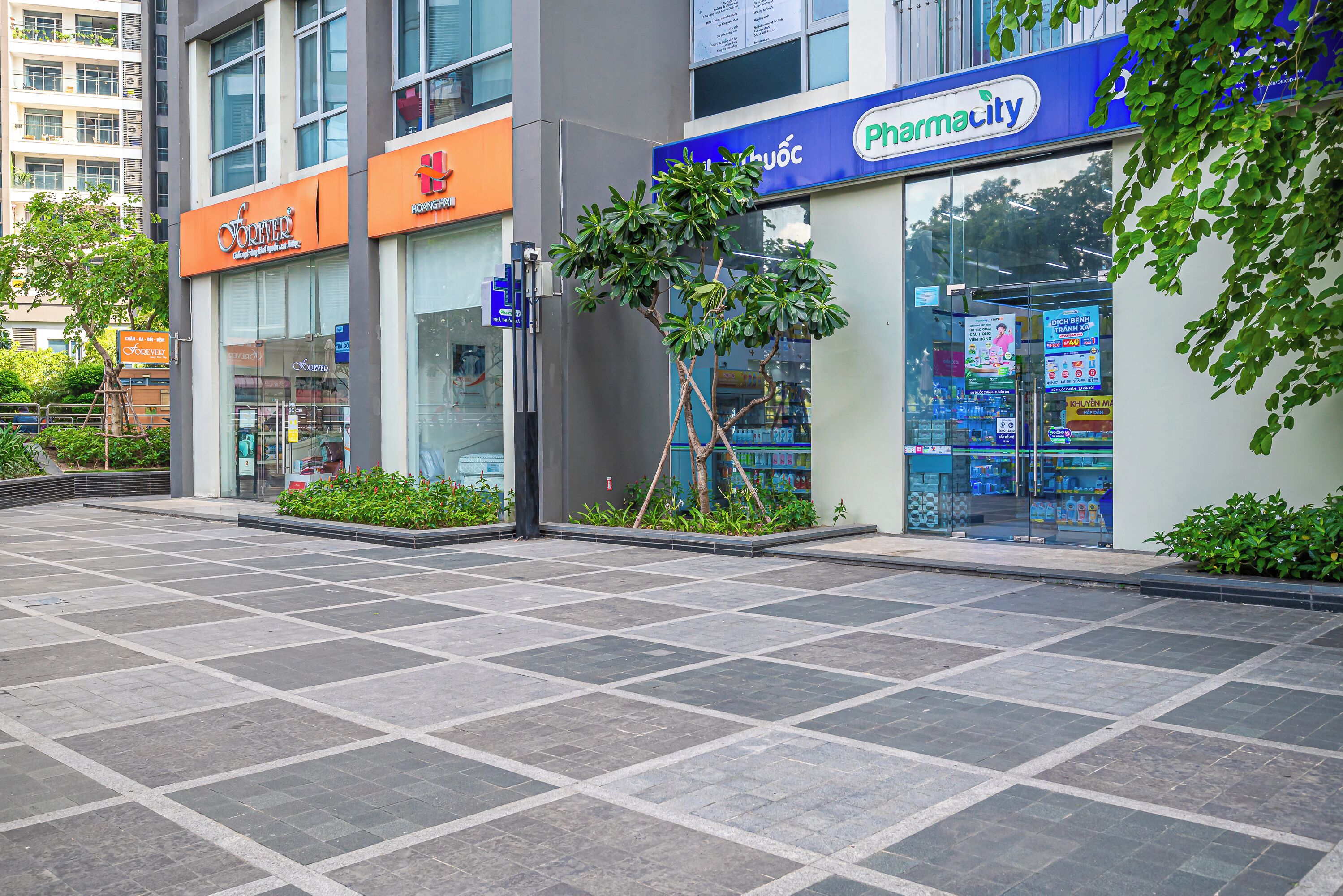 A pharmacy with a blue sign and a storefront with a glass window.
