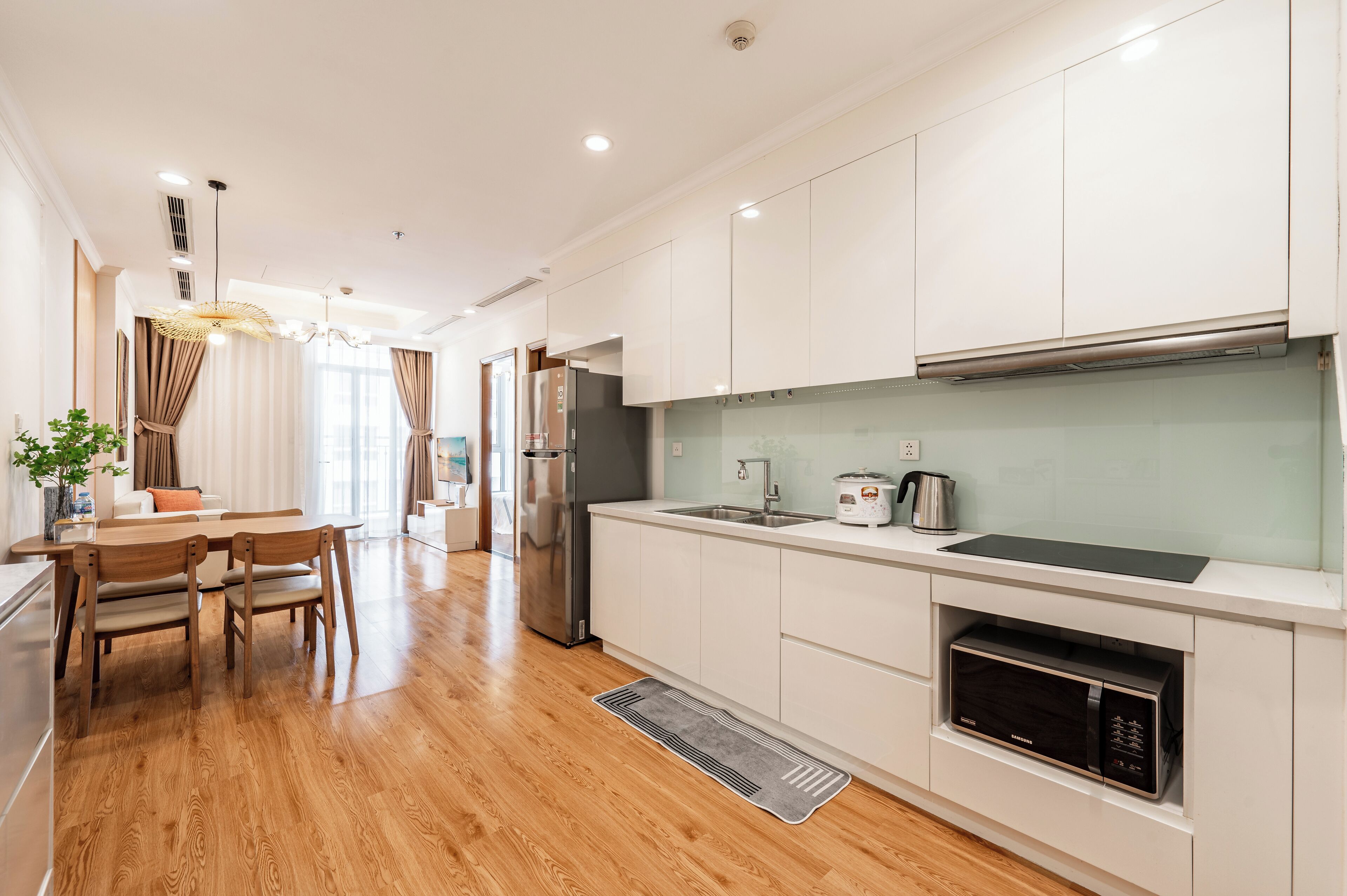 A modern kitchen with white cabinets, stainless steel appliances, and a built-in microwave.