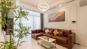 A modern living room with a brown leather sofa, a coffee table, and a large window with blinds.