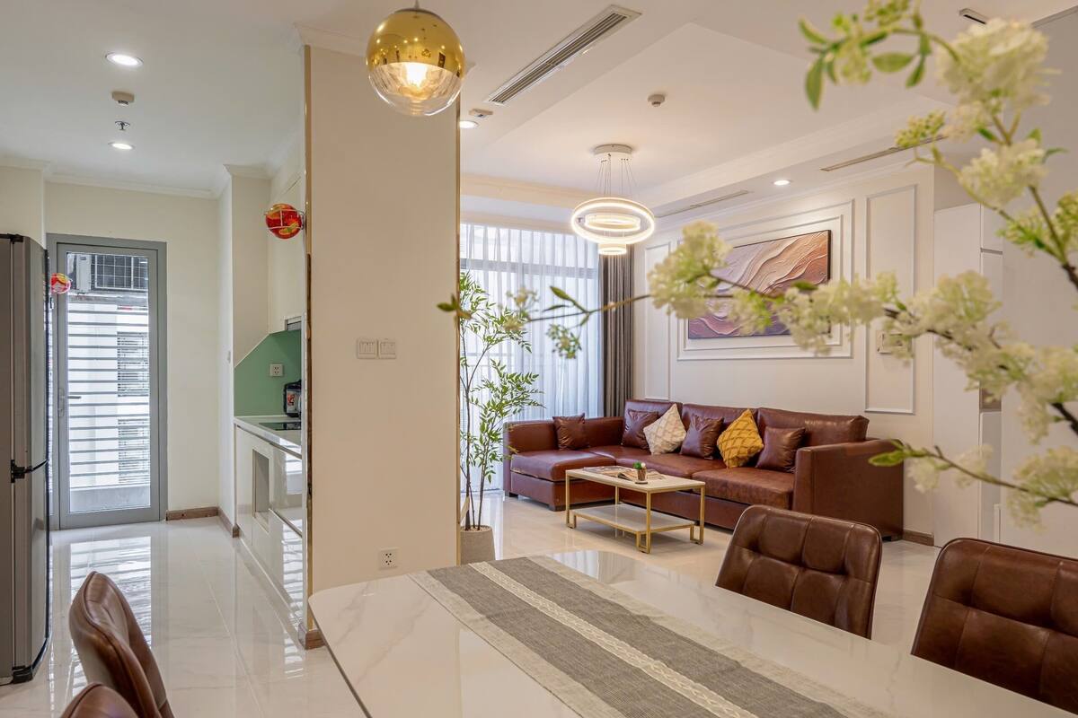 A modern living room with a sofa, coffee table, and dining area.