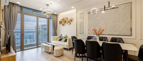 Un salon moderne avec un coin repas, de grandes fenêtres et une vue sur la ville.
