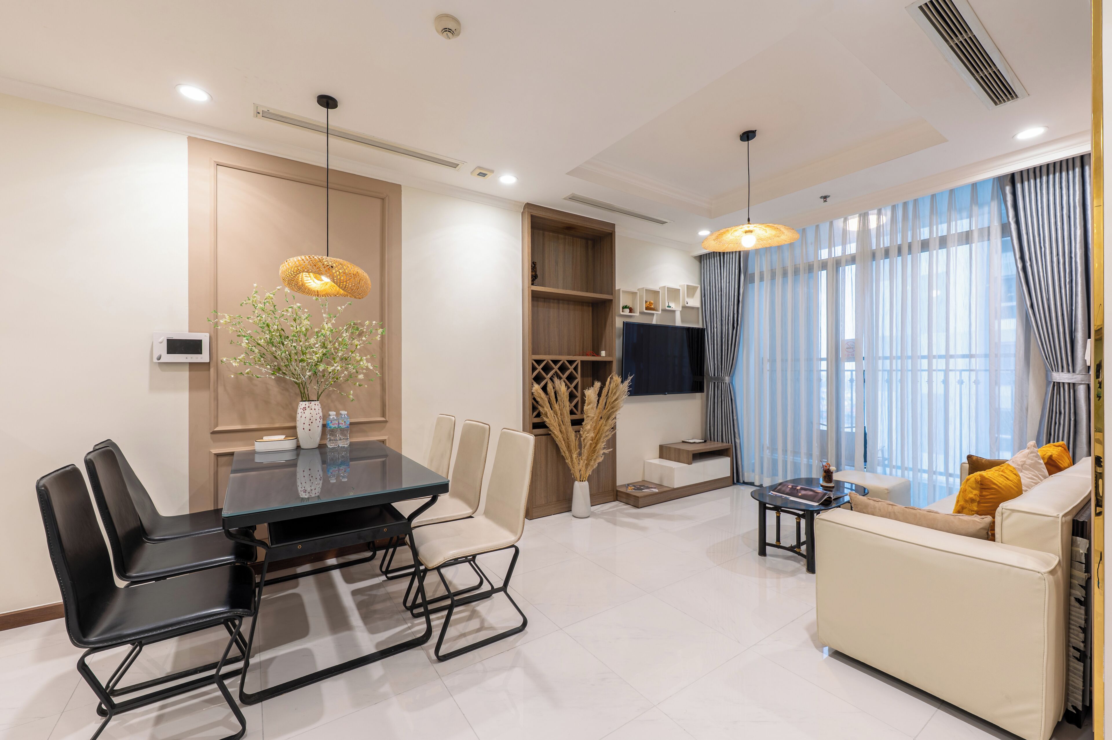 A modern living room with a dining area, a sofa, and a TV.