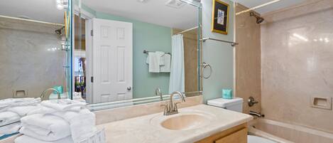A bathroom with a sink, mirror, and shower.
