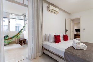 A hotel room with a bed, a hammock, a small table, and a TV in the corner. - 4 Minutes From Copacabana Beach Nsc205 (Rio de Janeiro)