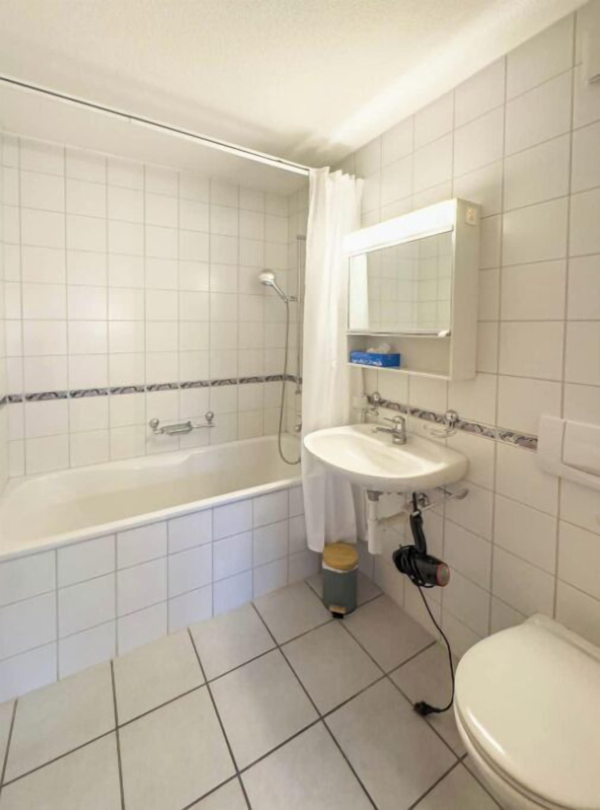 Ett badrum med badkar, handfat och toalett.