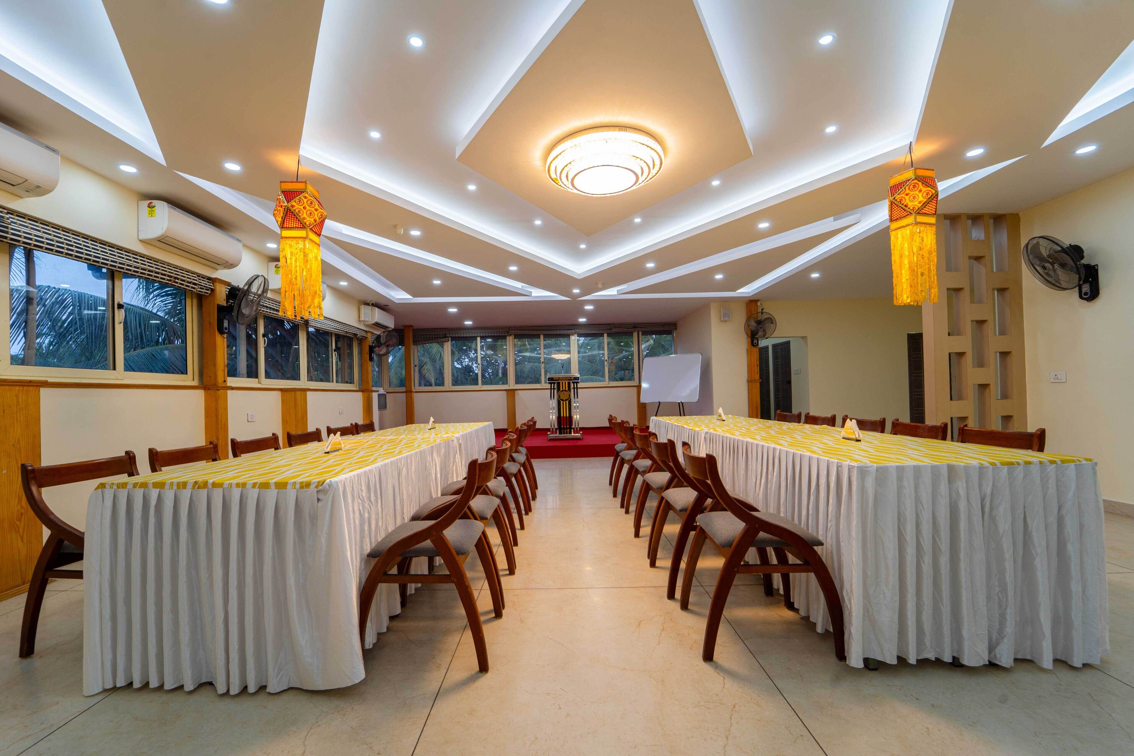Une salle de conférence avec une longue table, des chaises et un pupitre.