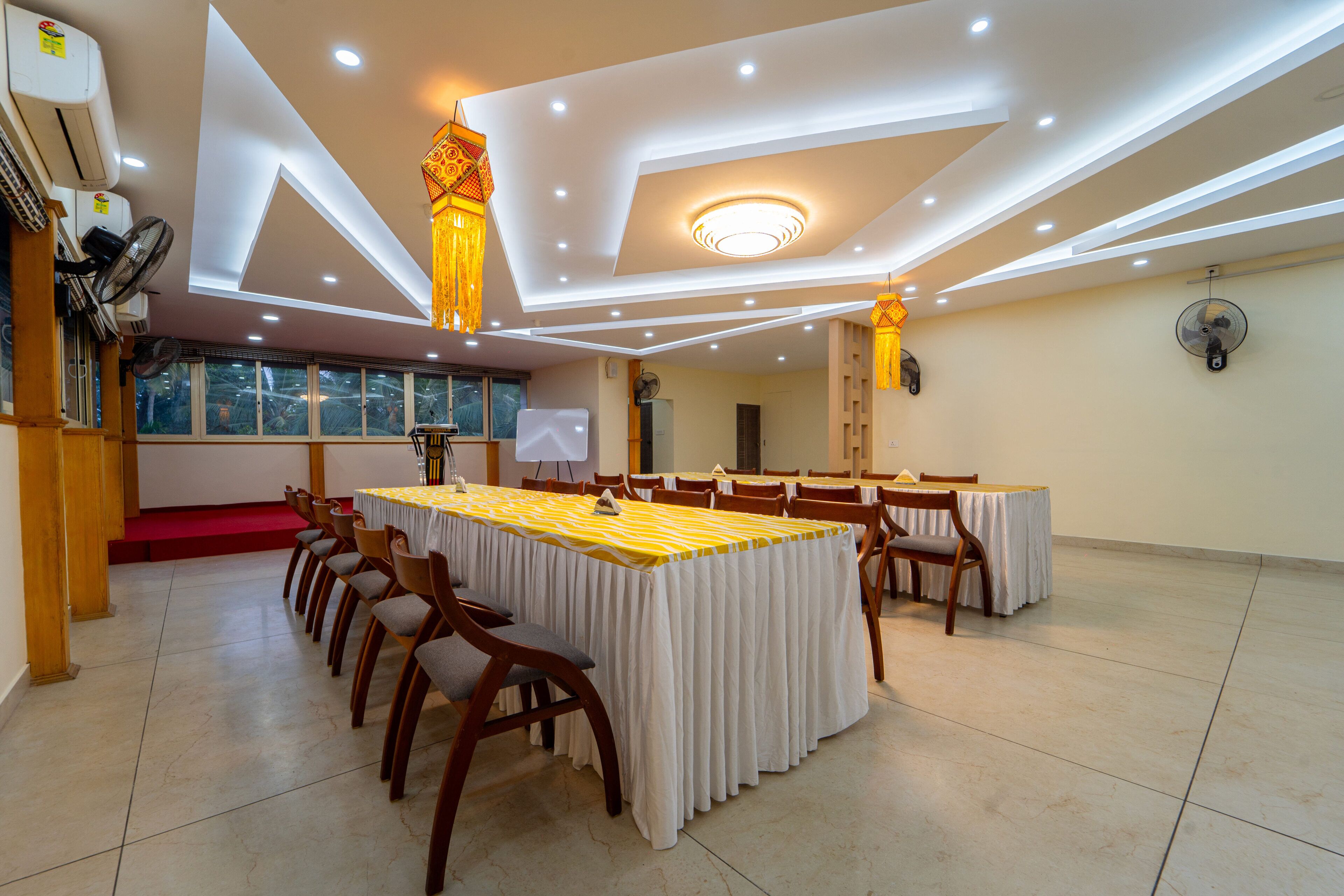 A conference room with a long table, chairs, and a ceiling with recessed lighting and decorative elements.
