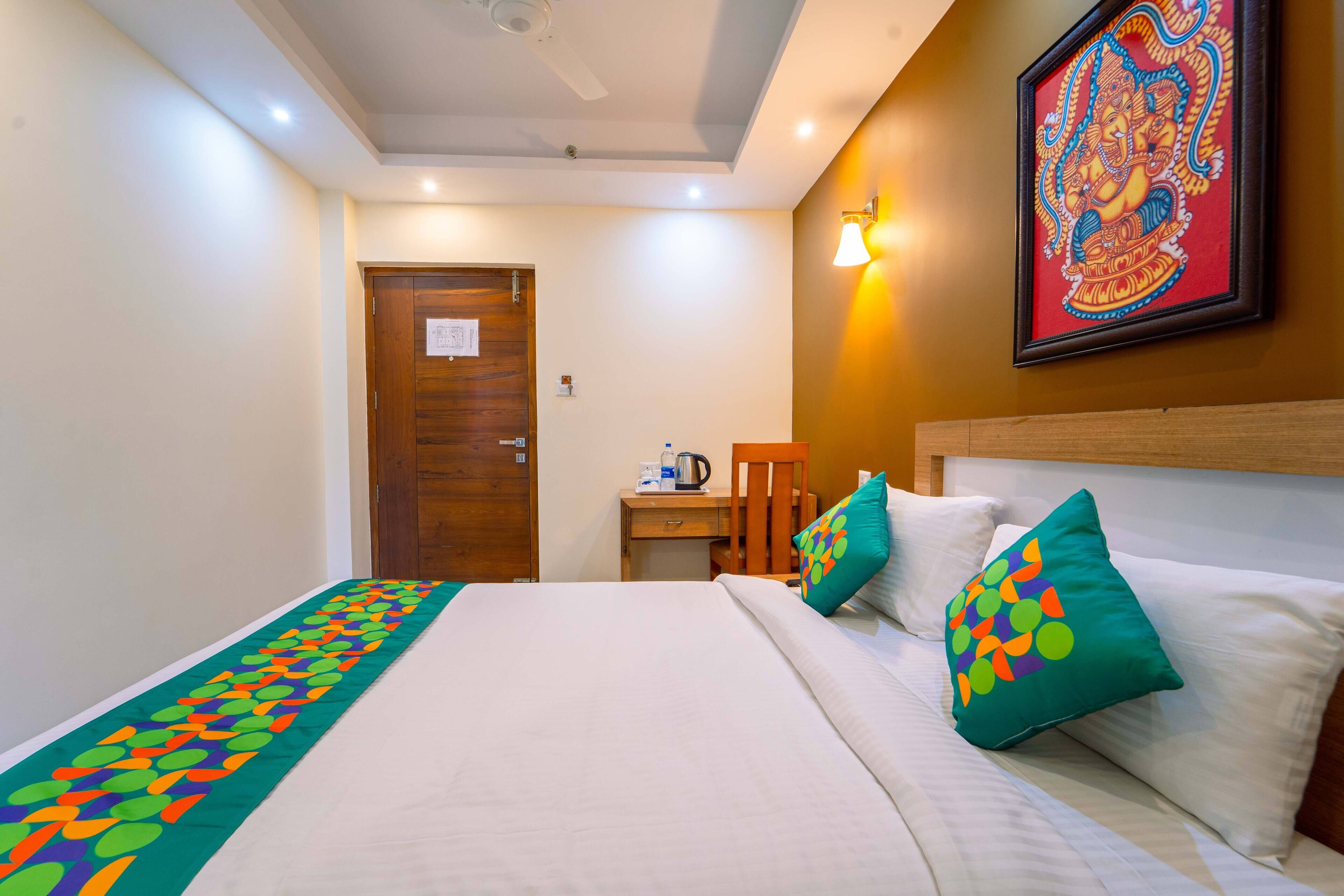 A hotel room with a bed, a desk, and a chair.