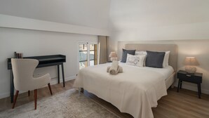 A bedroom with a bed, bedside tables, a chair, and a desk. - The Fort of Old Town 3 by Our Madeira (Funchal)