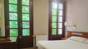 A hotel room with a bed, a desk, and two windows. - HOTEL LAUAXETA MUNGUIA (Mungia)