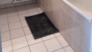 Ein Badezimmer mit Dusche, Waschbecken und Spiegel.