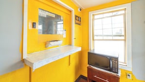 A small kitchen with a microwave, a window, and a sign indicating free WiFi. - Alamo Oasis Inn And Suites By Oyo San Antonio (San Antonio)