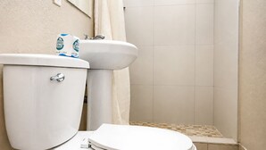 A bathroom with a toilet, sink, and shower. - Sai Park Motel (Lancaster)