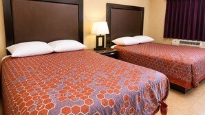 A hotel room with two beds, each with a headboard, a nightstand with a lamp, and a window with curtains. - Sai Park Motel (Lancaster)
