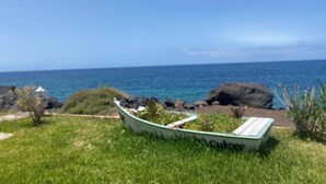 A boat named "Cuisinier" on a grassy area with a view of the ocean. - Apt. El Guirre Nº 8 - bajo (Valle Gran Rey)