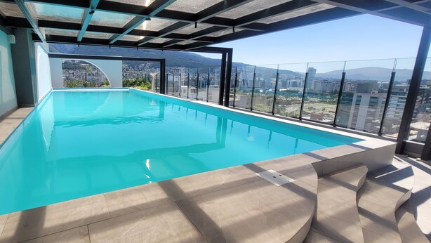 A rooftop infinity pool with a city view. - Harmony Luxury Apartments  (Quito)