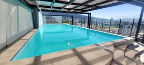 A rooftop infinity pool with a city view. - Harmony Luxury Apartments  (Quito)
