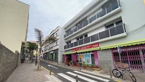 A street view with a pedestrian crossing, a bicycle parked on the sidewalk, and a building with a 'Coca-Cola' sign. - Apt. ManRey 2A - Turquesa (Valle Gran Rey)