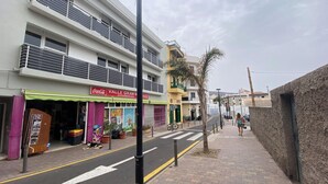 A street with a building featuring a 'Coca-Cola' sign and a 'Valle Gran R' sign, indicating a supermarket.