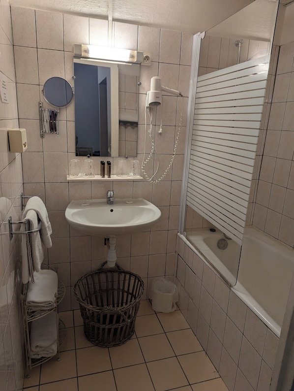 A bathroom with a sink, mirror, and shower. - HOTEL DU PARC (Montélimar)