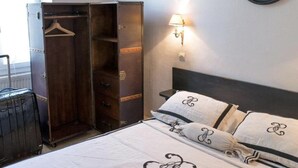 A bedroom with a bed, a wardrobe, and a wall-mounted lamp. - HOTEL DU PARC (Montélimar)