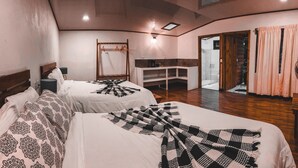 Een slaapkamer met twee bedden, een spiegel, een kaptafel en een inloopkast.