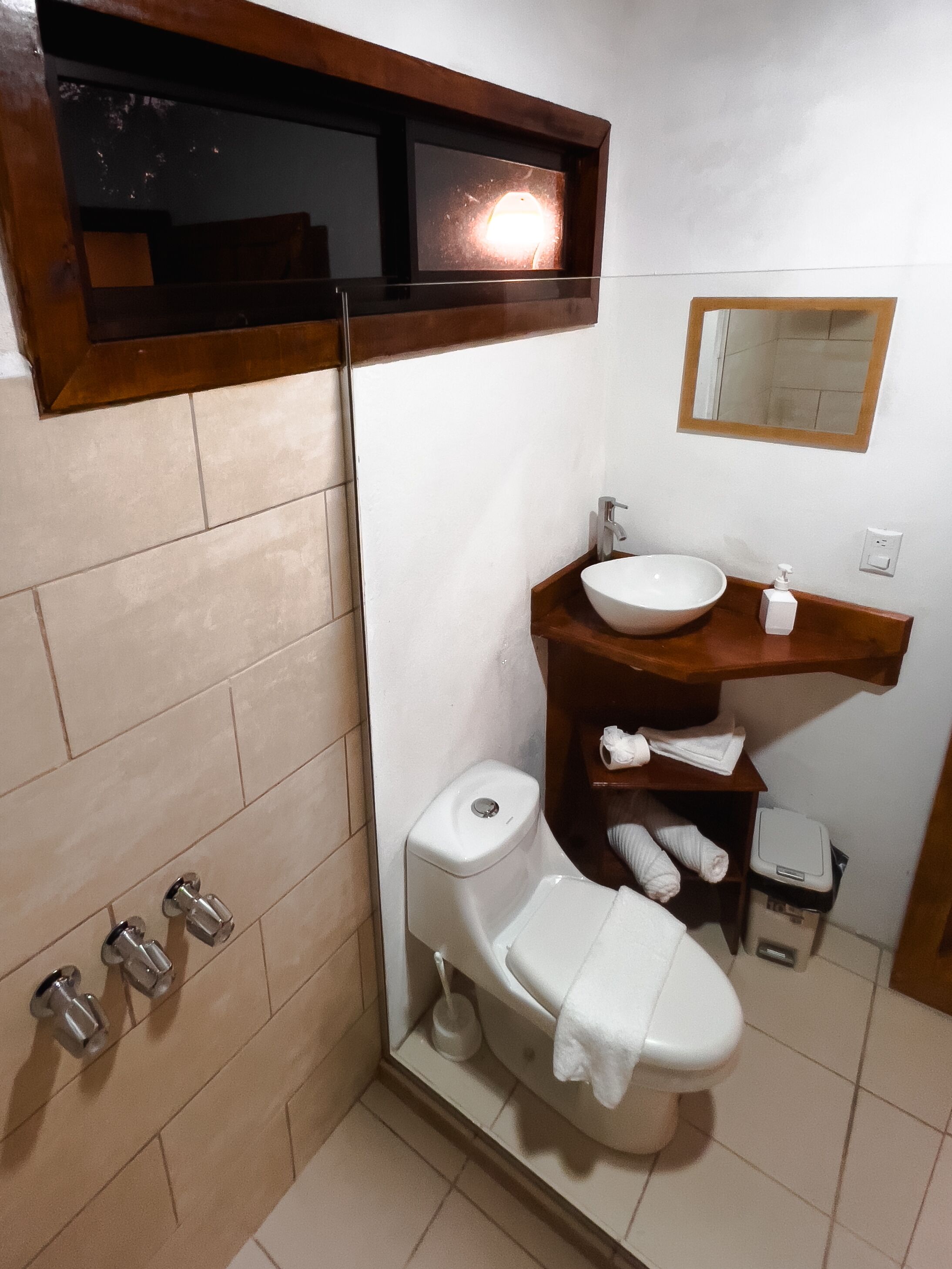 Un baño con inodoro, lavabo y espejo.