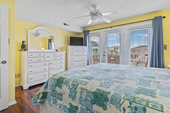 Un dormitorio con cama, cómoda, espejo y ventilador de techo.