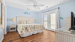 A bedroom with a bed, nightstands, a ceiling fan, a television, and a balcony with a view. - 4 BR Waterview Home- Pool- Gameroom- Sleeps 11 (North Myrtle Beach)