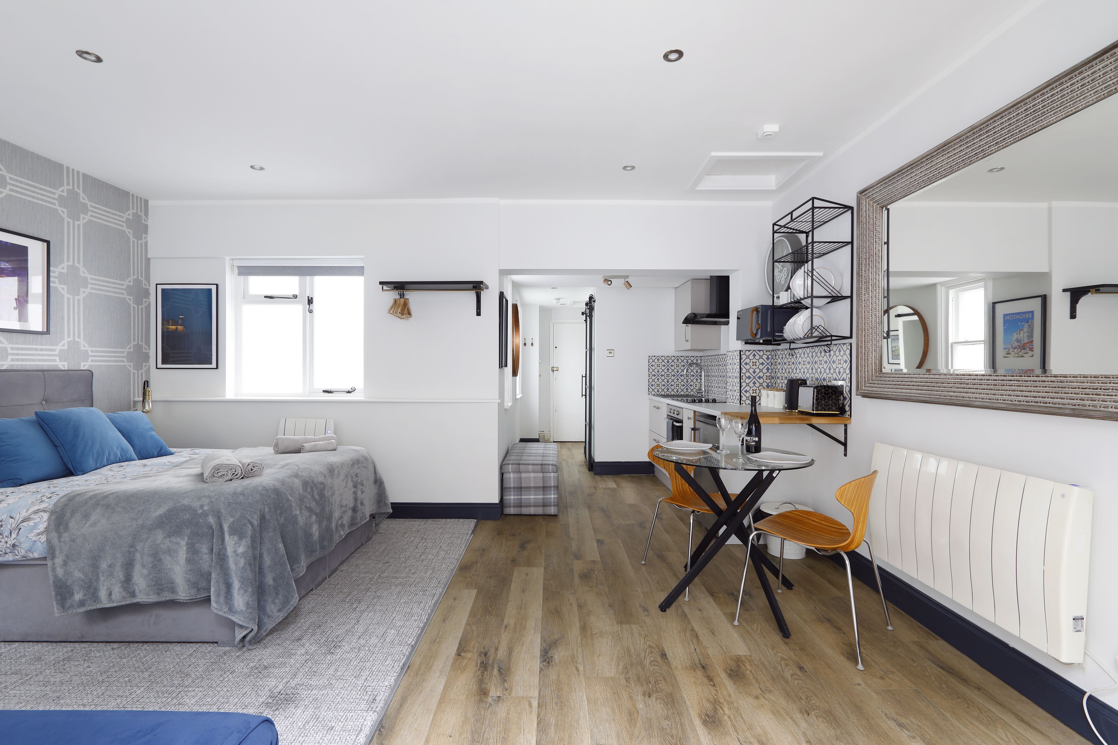 Ein modernes Schlafzimmer mit Bett, Nachttisch und einem großen Spiegel.