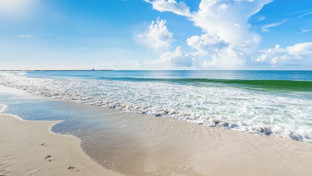 Una platja amb cel blau i onades.