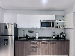 Enjoy cooking in this fully equipped kitchen with a refrigerator, microwave, and countertop space for your appliances.