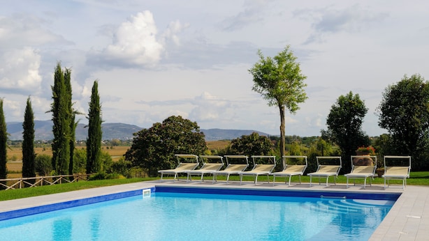 A swimming pool with lounge chairs and a view of the countryside.