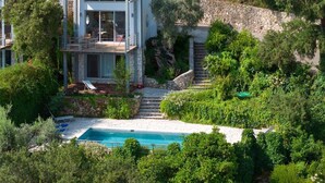 A two-story house with a pool, surrounded by lush greenery and a stone wall. - Villa Milos - Three Bedroom Villa, Sleeps 6 (Lefkada)