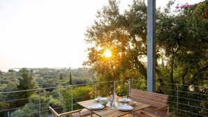 A wooden deck with a table set for two, overlooking a scenic landscape. - Villa Milos - Three Bedroom Villa, Sleeps 6 (Lefkada)