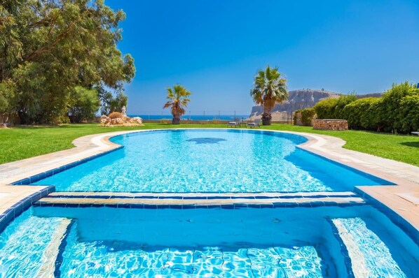 A swimming pool with a clear view of the ocean in the background.
