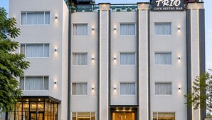 A modern hotel with a glass facade, a rooftop terrace, and a sign for a cafe/restro bar. - Hotel Three Seasons (Panigaon)