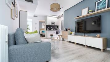 Relax in this stylish living space with a sofa, entertainment unit, and dining area.