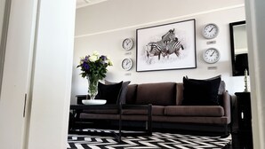 A modern living room with a brown sofa, a coffee table, and a framed zebra artwork on the wall. - 21 Cheviot Place (Cape Town)