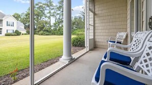 A covered porch with two white plastic chairs and a concrete floor. - Fairway Dunes 2 BR Condo w/ Private lockout unit, Pool, Golf, Medical Center (Little River)