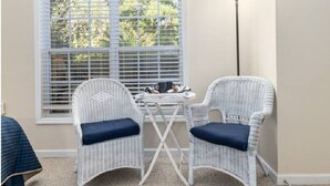 A corner room with two wicker chairs, a small round table, and a window with blinds. - Fairway Dunes 2 BR Condo w/ Private lockout unit, Pool, Golf, Medical Center (Little River)