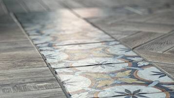 A close-up of a patterned floor with a wooden border.
