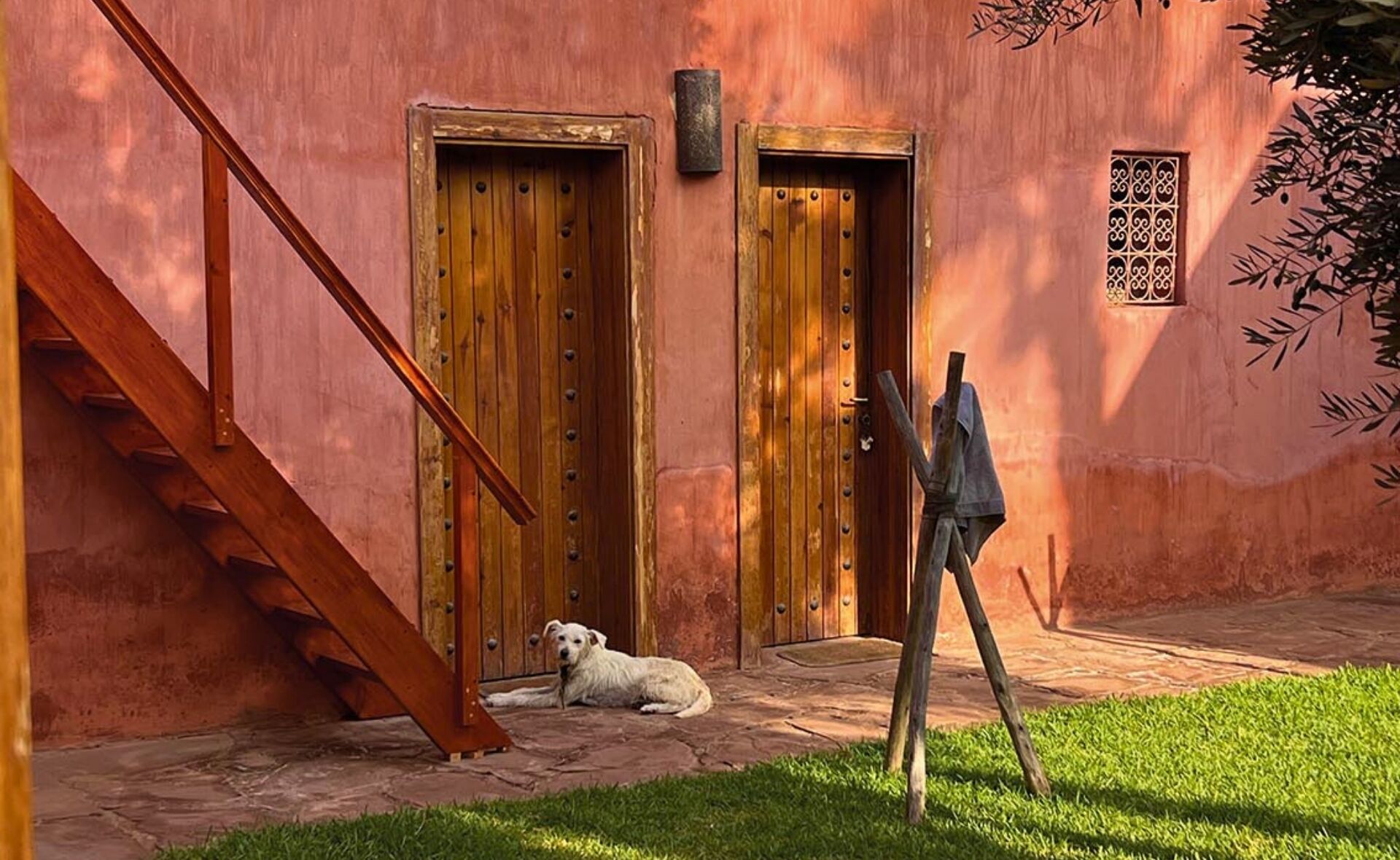Un edificio rústico con puertas de madera y una escalera.